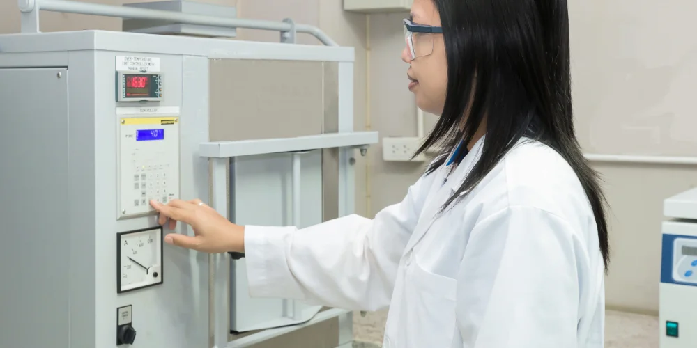 Scientist in laboratory with high temperature muffle furnace