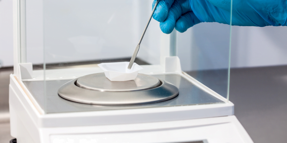 Sample being added to analytical balance