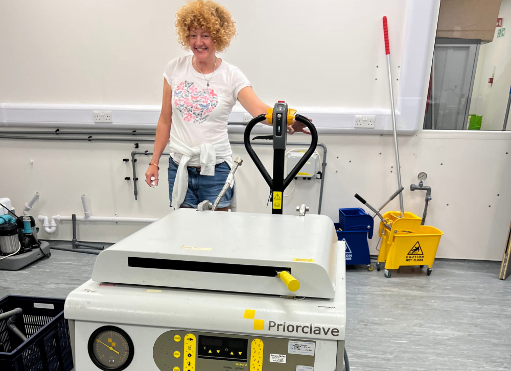 Lisa using forklift to move large autoclave