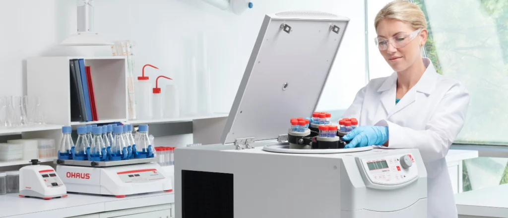 Woman placing rotor into an Ohaus centrifuge