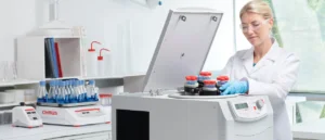 Woman placing rotor into an Ohaus centrifuge