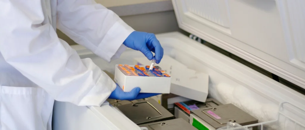 Scientist putting samples into a chest freezer
