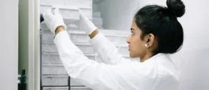 Scientist placing samples into a laboratory freezer