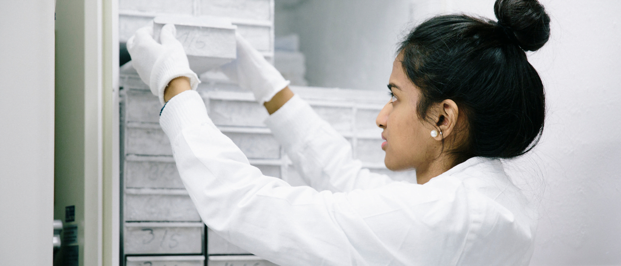 Scientist placing samples into a laboratory freezer