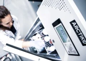 Scientist placing sample into laboratory refrigerator
