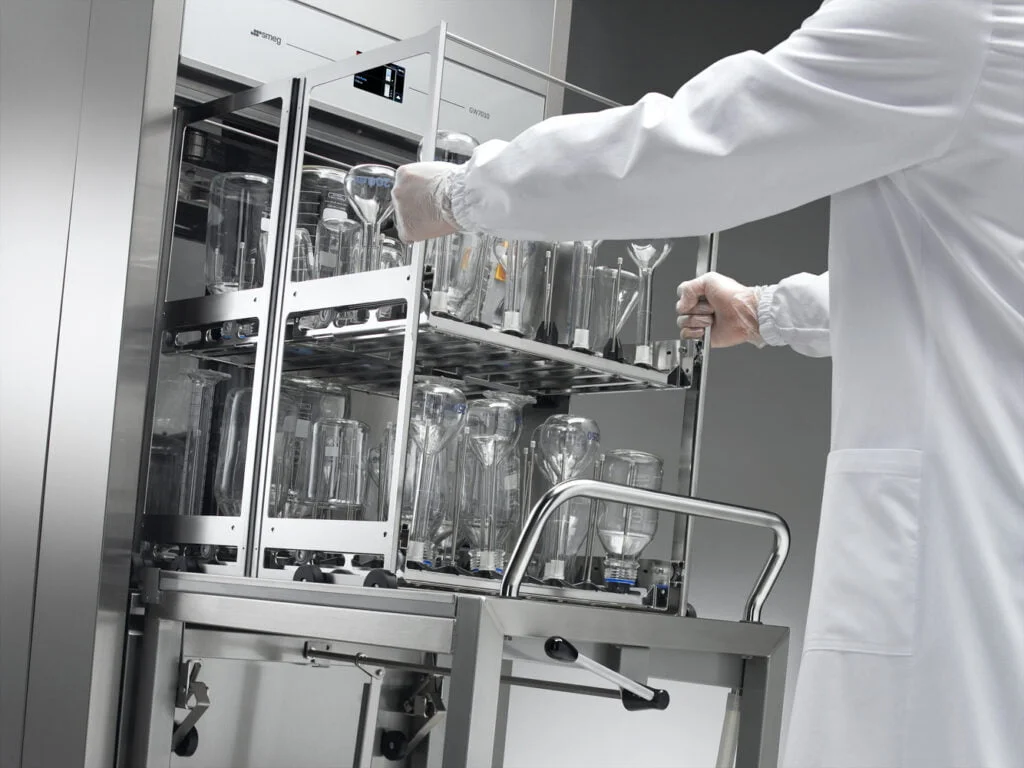 Scientist removing clean glassware from SMEG labwasher