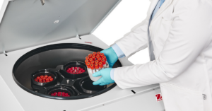 Scientist placing samples into and Ohaus centrifuge