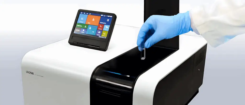 Scientist placing a sample cuvette into a UV-vis spectrometer